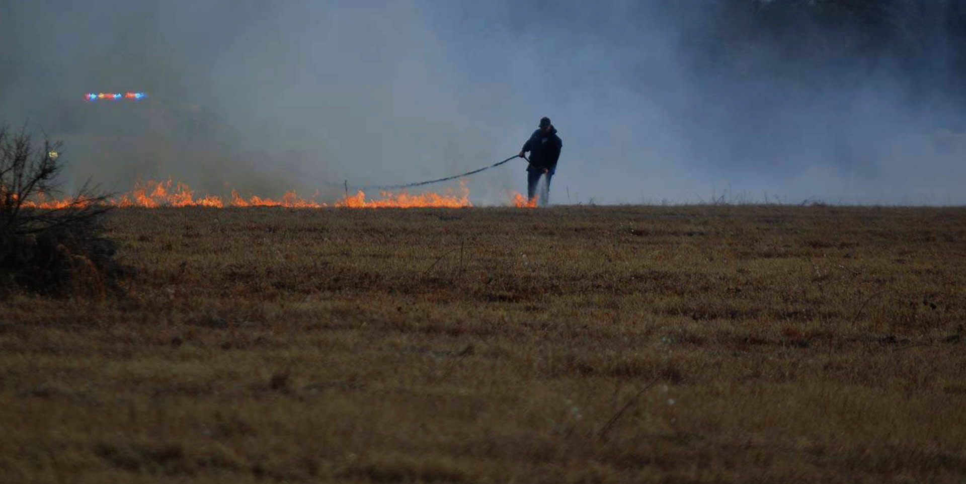 Fire fighters battling a field on fire.